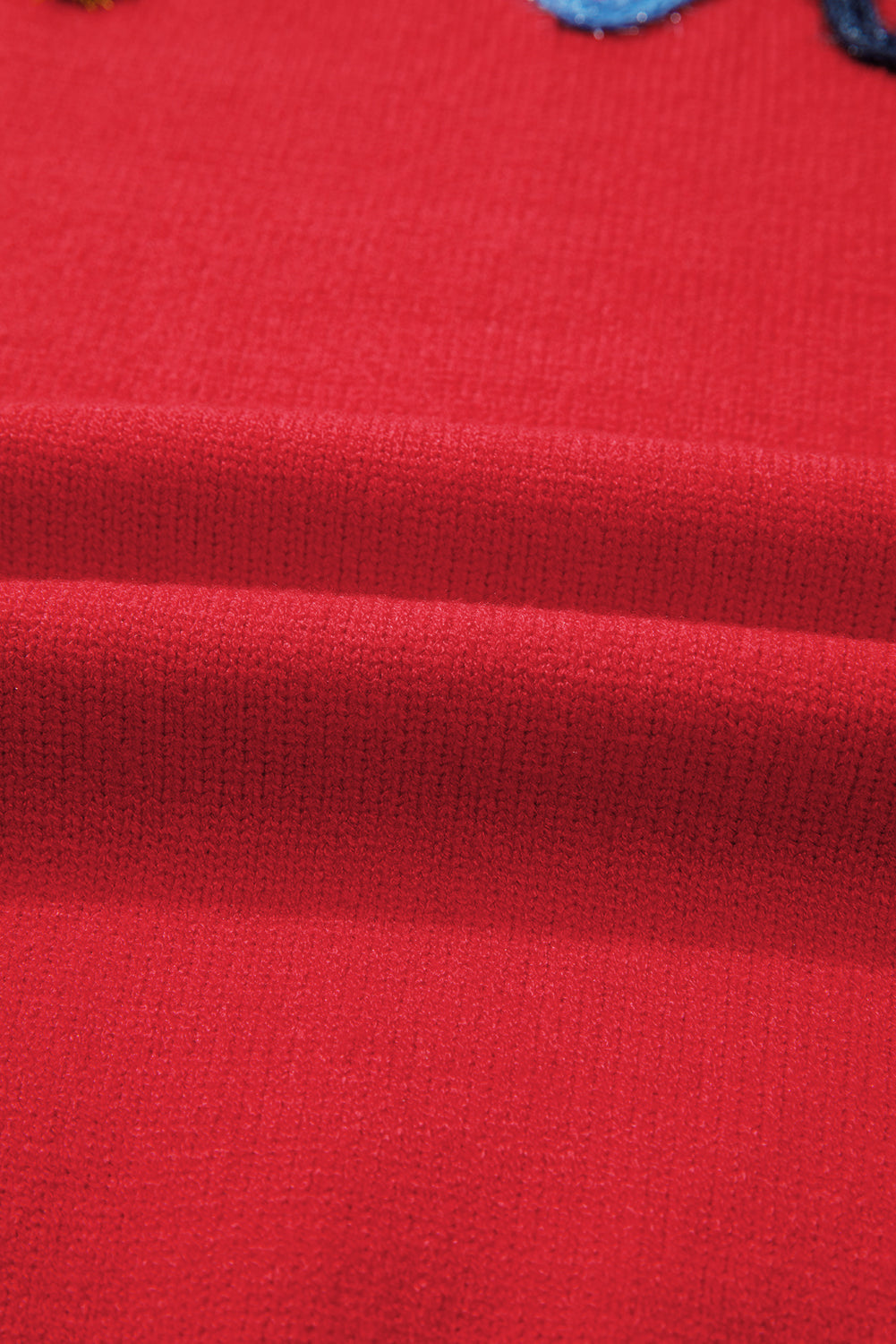 Feurig-roter Pullover mit Lametta-Muster und überschnittener Schulter