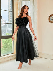 Schwarzes Abendkleid aus Netzstoff mit Neckholder und Federn